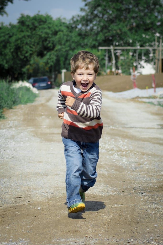 Boy Wearing Red, Brown, and White Stripe Sweater Running Photo